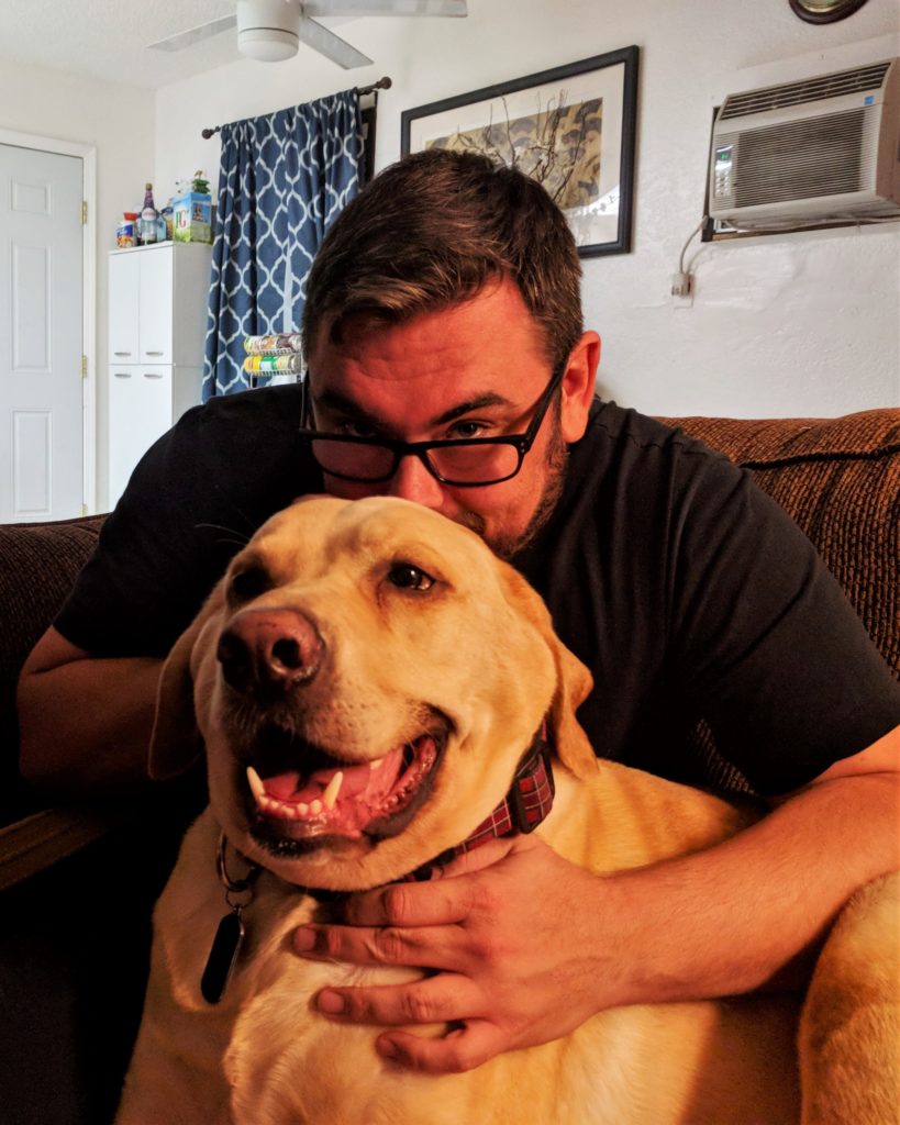 A man hugging a dog.